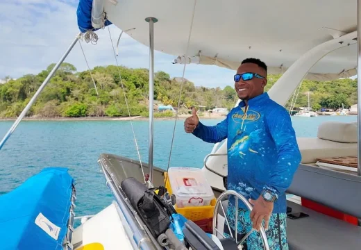 Capitaine à la barre du catamaran Adventurer pendant une croisière à Nosy Be