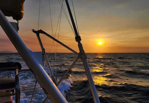 Coucher de soleil sur le catamaran Adventurer avec une canne de pêche visible à Nosy Be