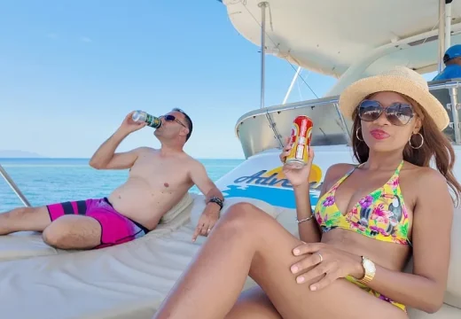 Couple buvant l'apéritif sur le pont avant du catamaran Adventurer à Nosy Be