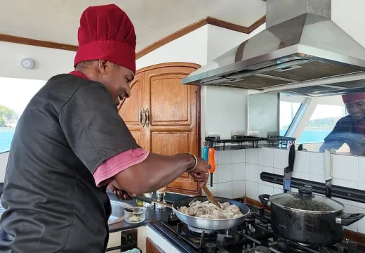 Cuisinier en action dans la cuisine du catamaran Adventurer à Nosy Be