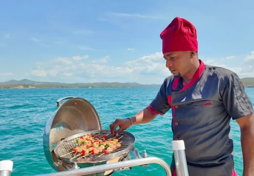 Cuisinier faisant des grillades sur le catamaran Adventurer en croisière à Nosy Be