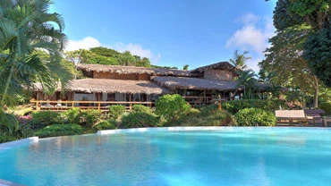 Piscine du Manga Soa Lodge à Nosy Be avec restaurant en arrière-plan