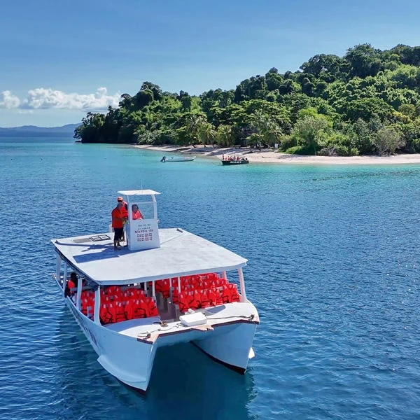 Catamaran touristique en excursion à Nosy Be devant une plage tropicale et eau turquoise