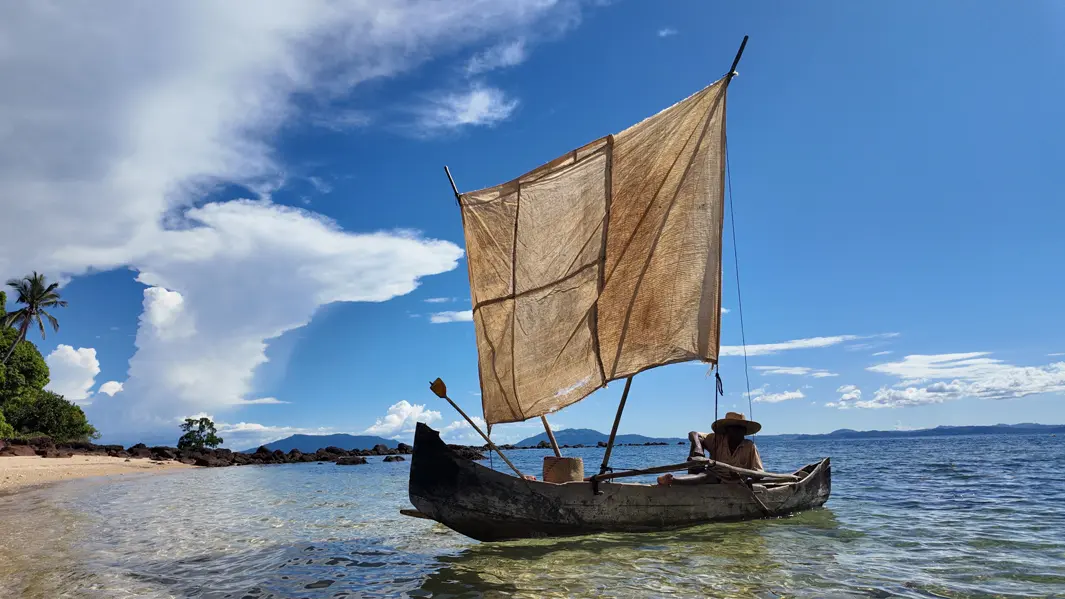 Plage de sable blanc avec pirogue traditionnelle à Nosy Faly Madagascar
