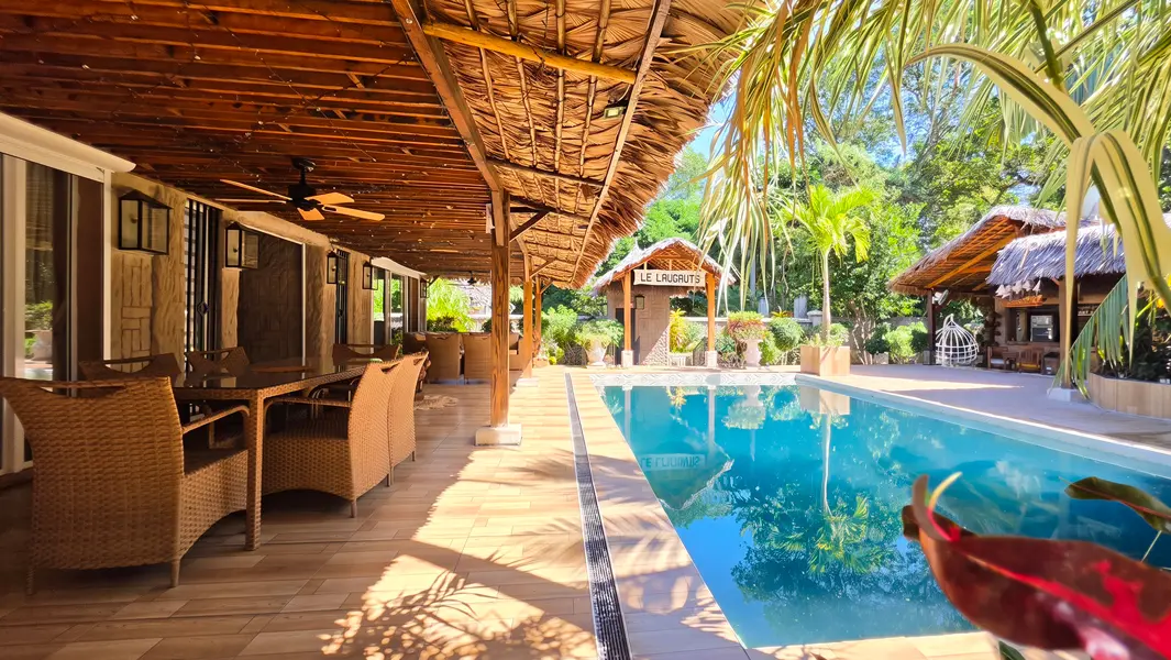 Piscine 5 × 9 mètres entourée de terrasses et de jardins paysagers.