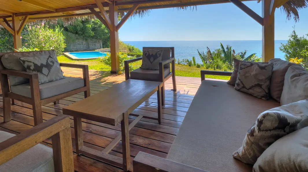 Salon extérieur couvert avec vue sur la piscine et le canal du Mozambique à Baobab, Nosy Be.