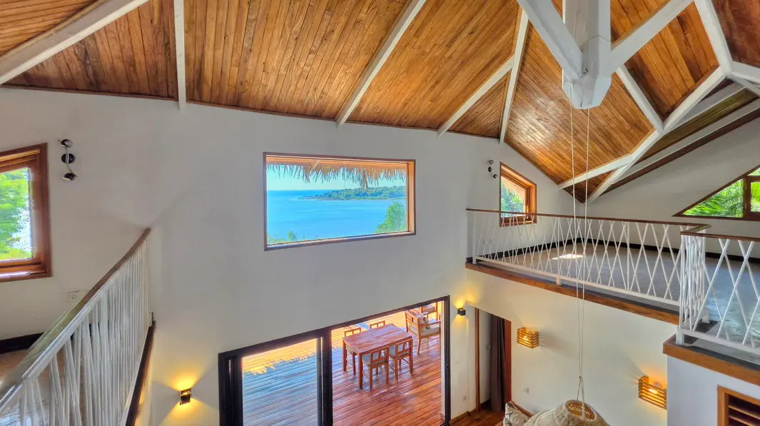 Mezzanine avec charpente apparente et vue panoramique sur le canal du Mozambique dans une villa à Baobab, Nosy Be